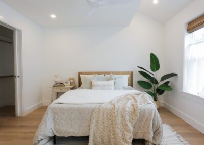 Renovated bedroom with wood flooring and vaulted ceiling