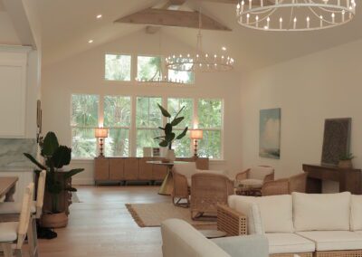 Open living room with vaulted beamed ceiling and chandeliers