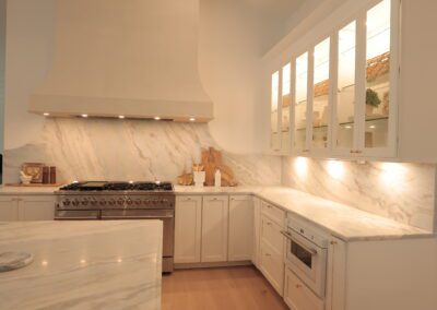 Kitchen with marble island and range under a beamed ceiling