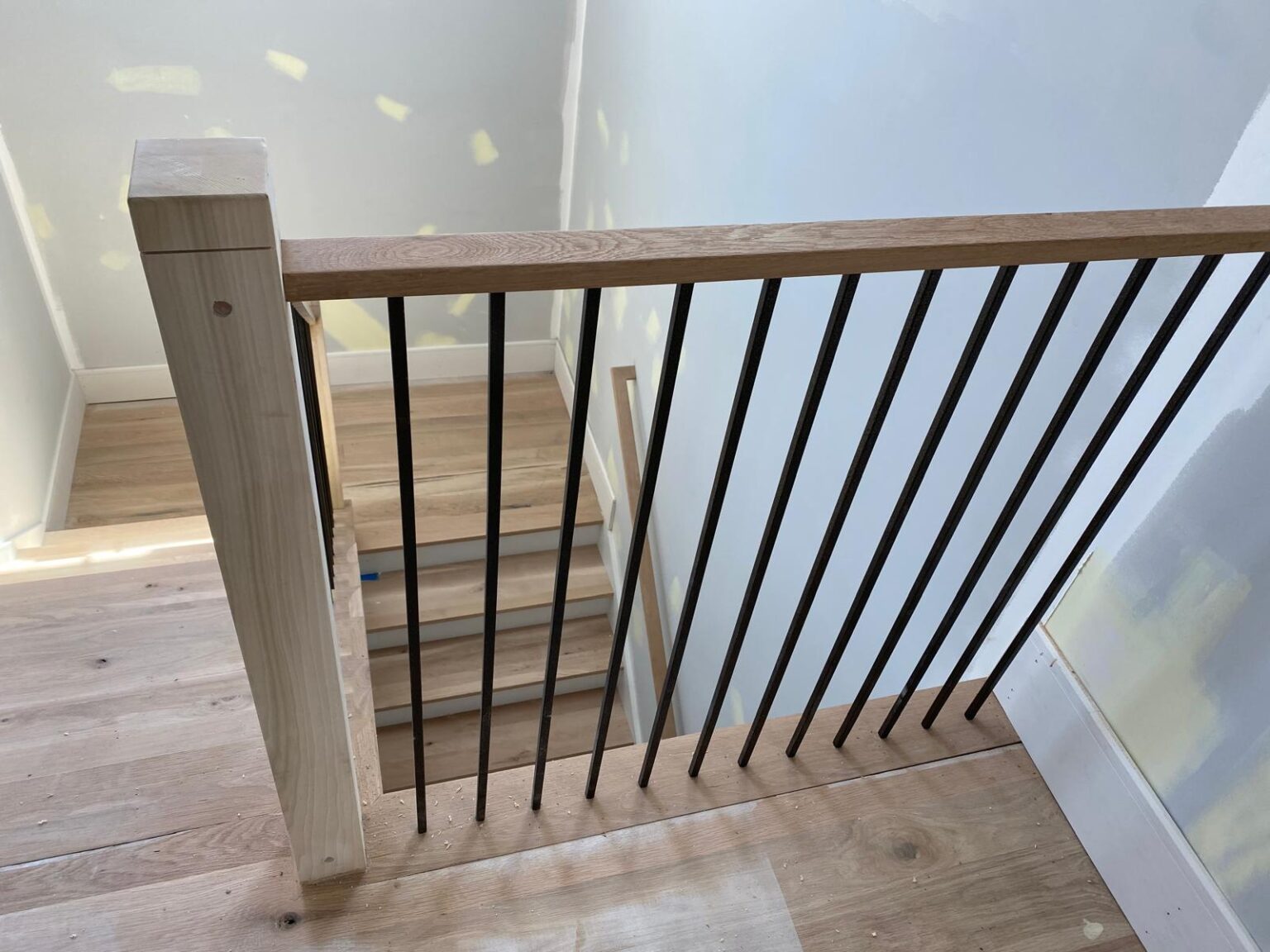 Wide-plank floor beside a new stair rail