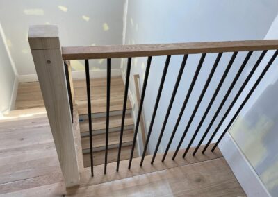 Wide-plank floor beside a new stair rail