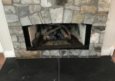 Stone fireplace surround with a slate hearth