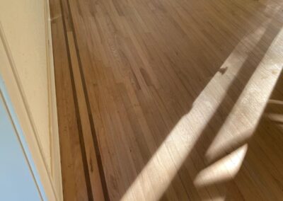 Hardwood floor meeting a floor vent and trim detail