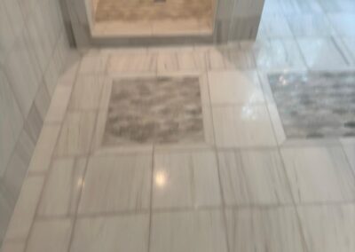 Marble tile bathroom floor with inset accent panel