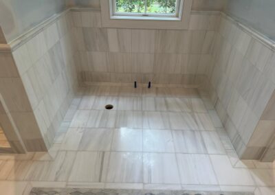 Large-format tile shower floor and surround in a remodeled bathroom