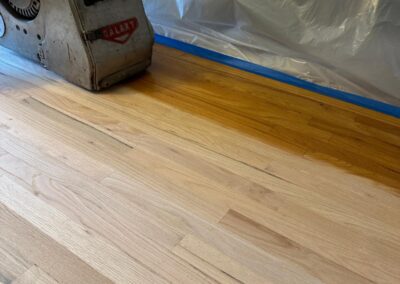 Floor sander at work on a hardwood floor during refinishing