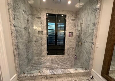Marble-look tile walk-in shower with mosaic floor, Charleston bathroom remodel by Wisebuild