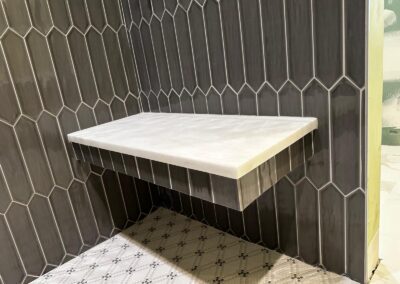 Picket tile shower wall with a stone bench seat