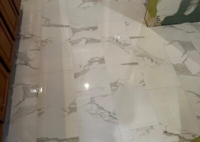 Herringbone tile shower floor with marble-look walls